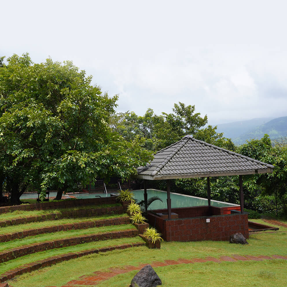 Grassy hill featuring a pavilion beside a pool